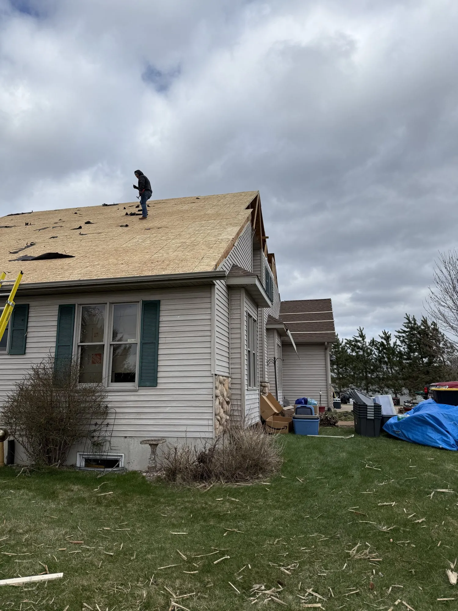 Shield Restoration worker on a residential roof after storm damage.