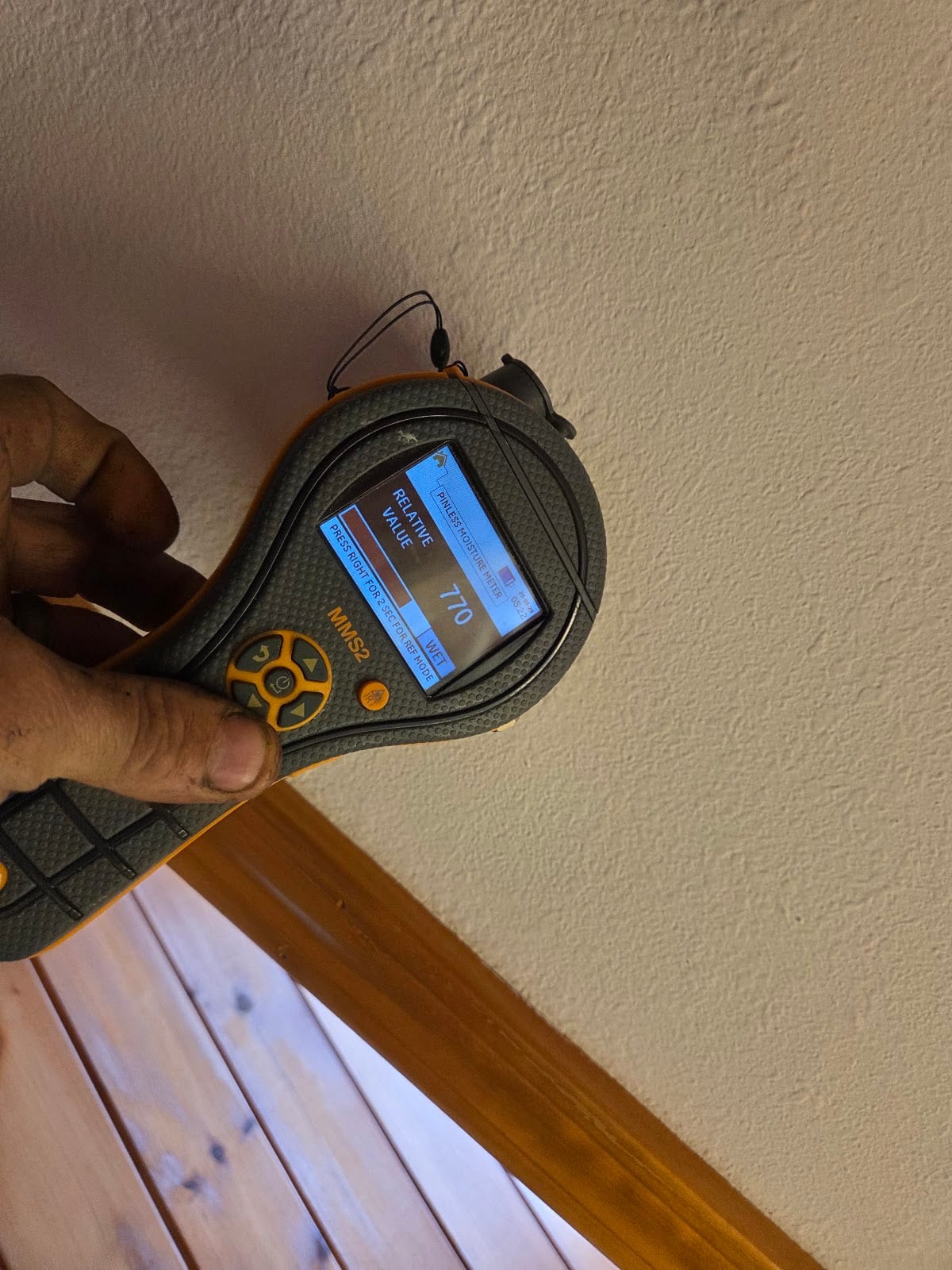 Protimeter moisture meter reading WET on a wall during assessment.