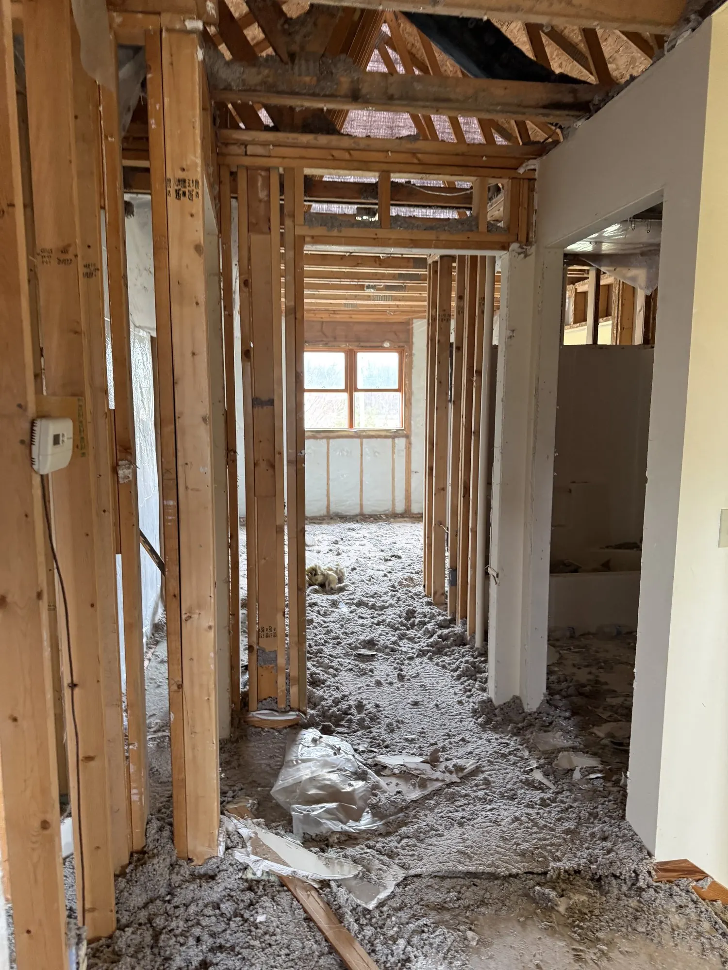 Fire-damaged interior gutted to studs and joists, swept clean for rebuild.