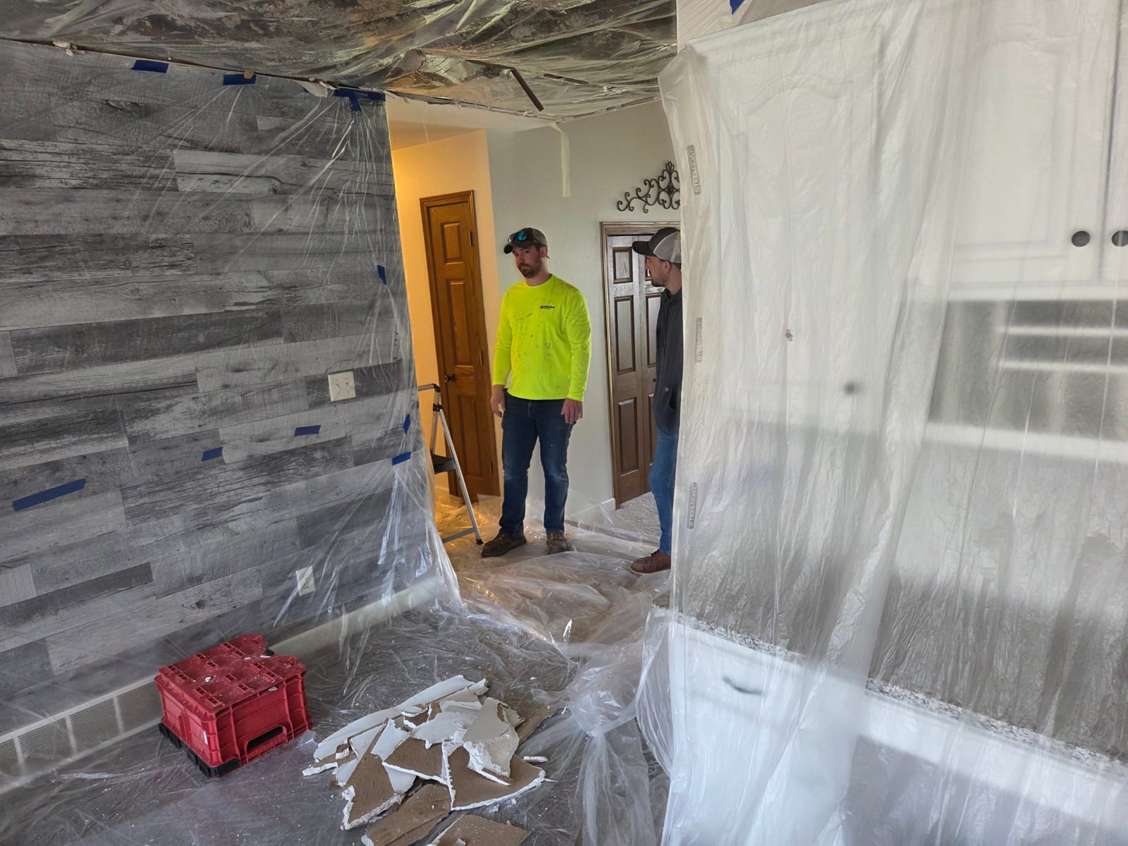Shield crew working inside sealed plastic containment during remediation.
