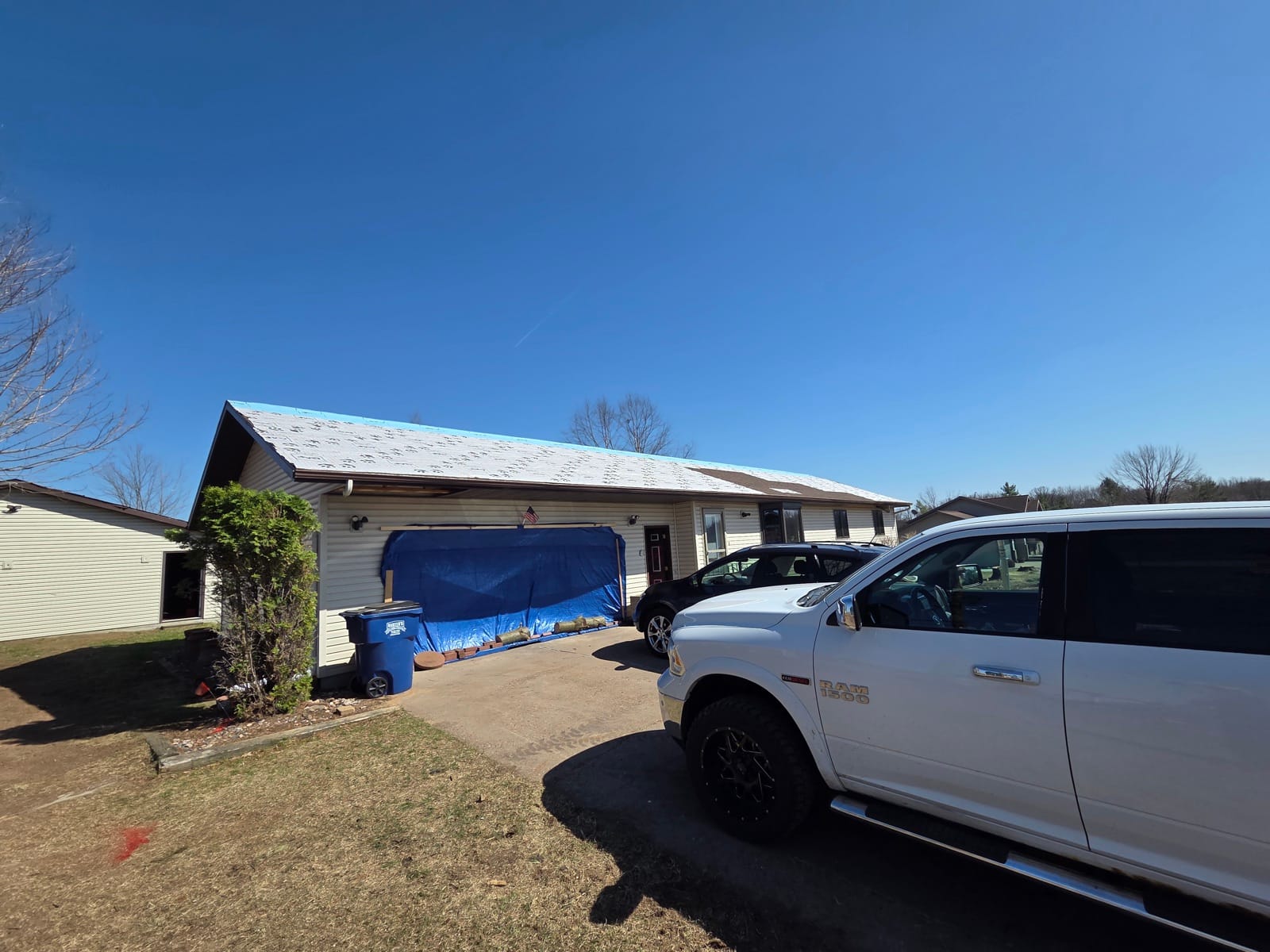 A Shield crew truck parked at a home secured under an emergency roof tarp.