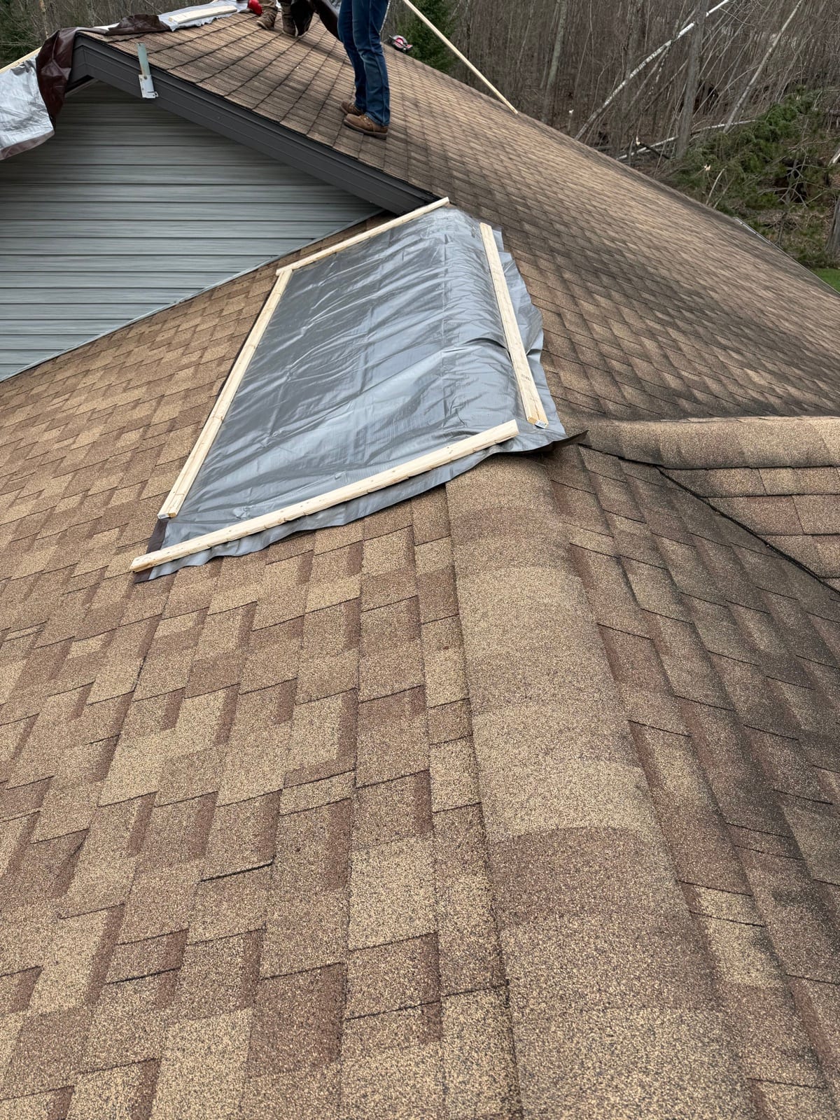 Emergency tarps battened over a damaged roof with lumber strapping.