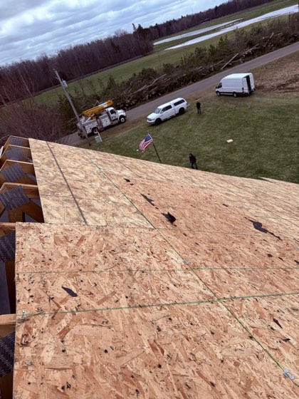 Looking down a fresh roof deck onto Shield trucks and the job site.