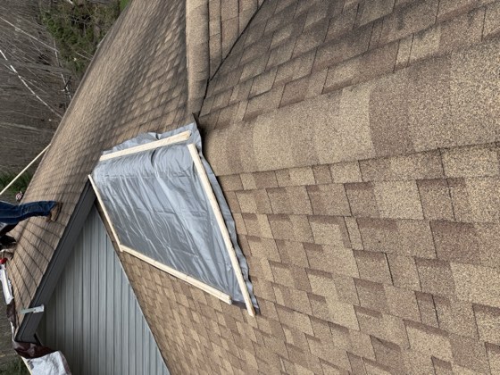 Emergency tarp installed over a damaged roof section.